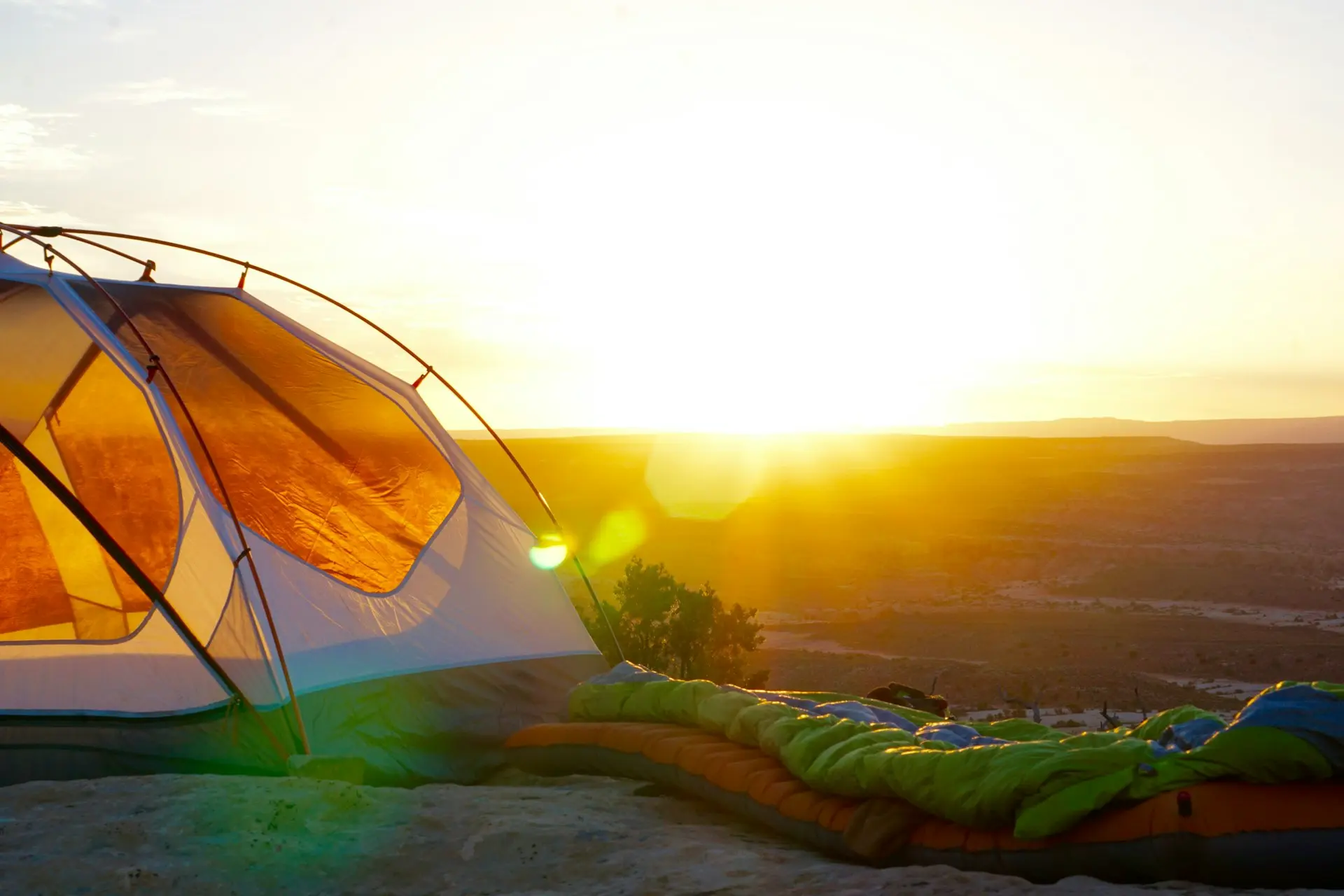 camping tent on cliff during golden hour